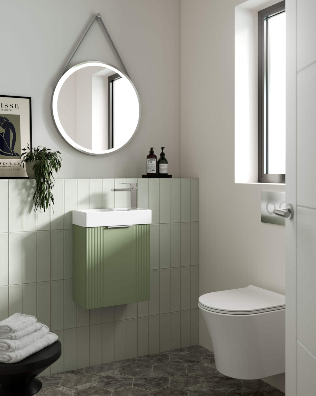 Sleek modern bathroom with a wall-mounted green vanity, round illuminated mirror, minimalist fixtures, natural light from window, and stylish decor in a contemporary design, perfect for Bubly Bathrooms.