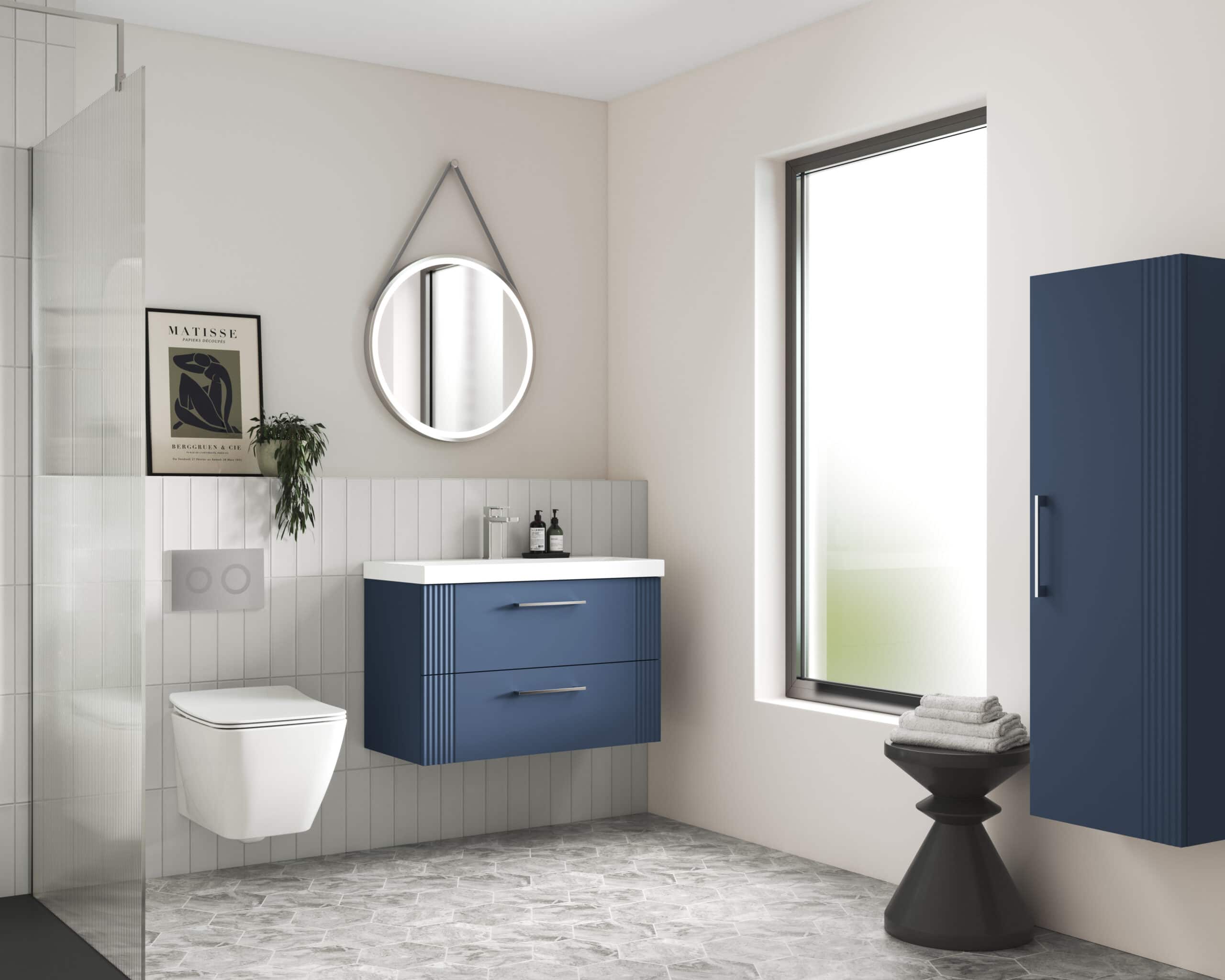 Modern bathroom with blue vanity, wall-mounted toilet, and sleek storage cabinet, featuring a round mirror, large window, and minimalistic design for contemporary bathroom decor.