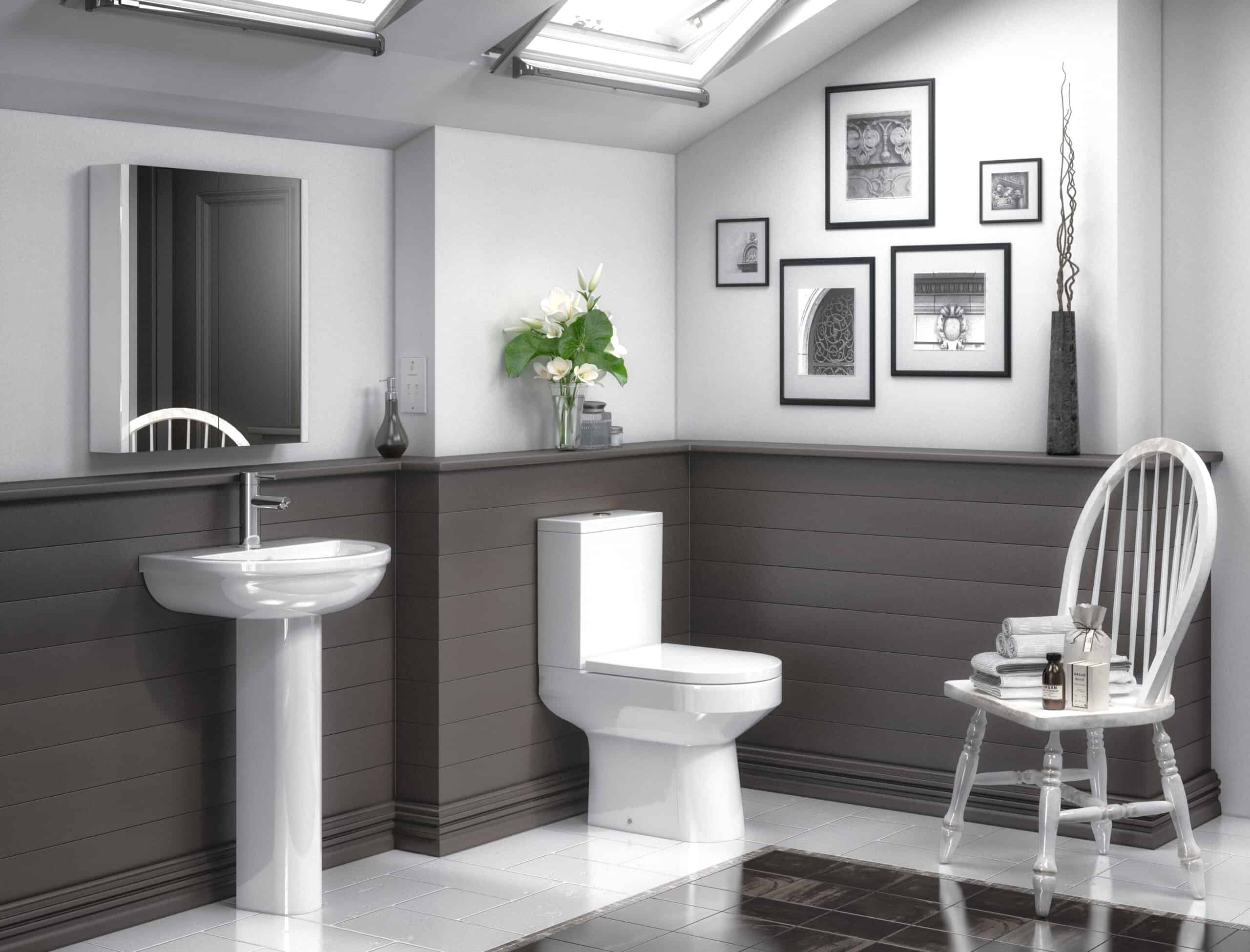 Luxurious bathroom with modern white toilet, pedestal sink, grey wall paneling, decorative framed art, and natural light from skylights, showcasing elegant and contemporary bathroom design.