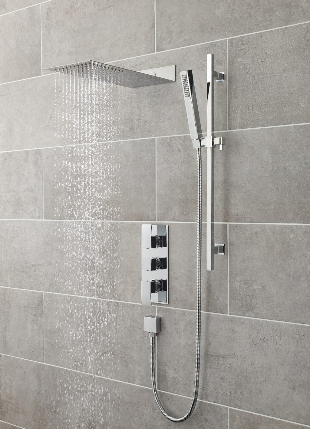 Modern chrome rainfall shower with handheld attachment in a contemporary bathroom, featuring grey tiled walls for a sleek, minimalistic look.