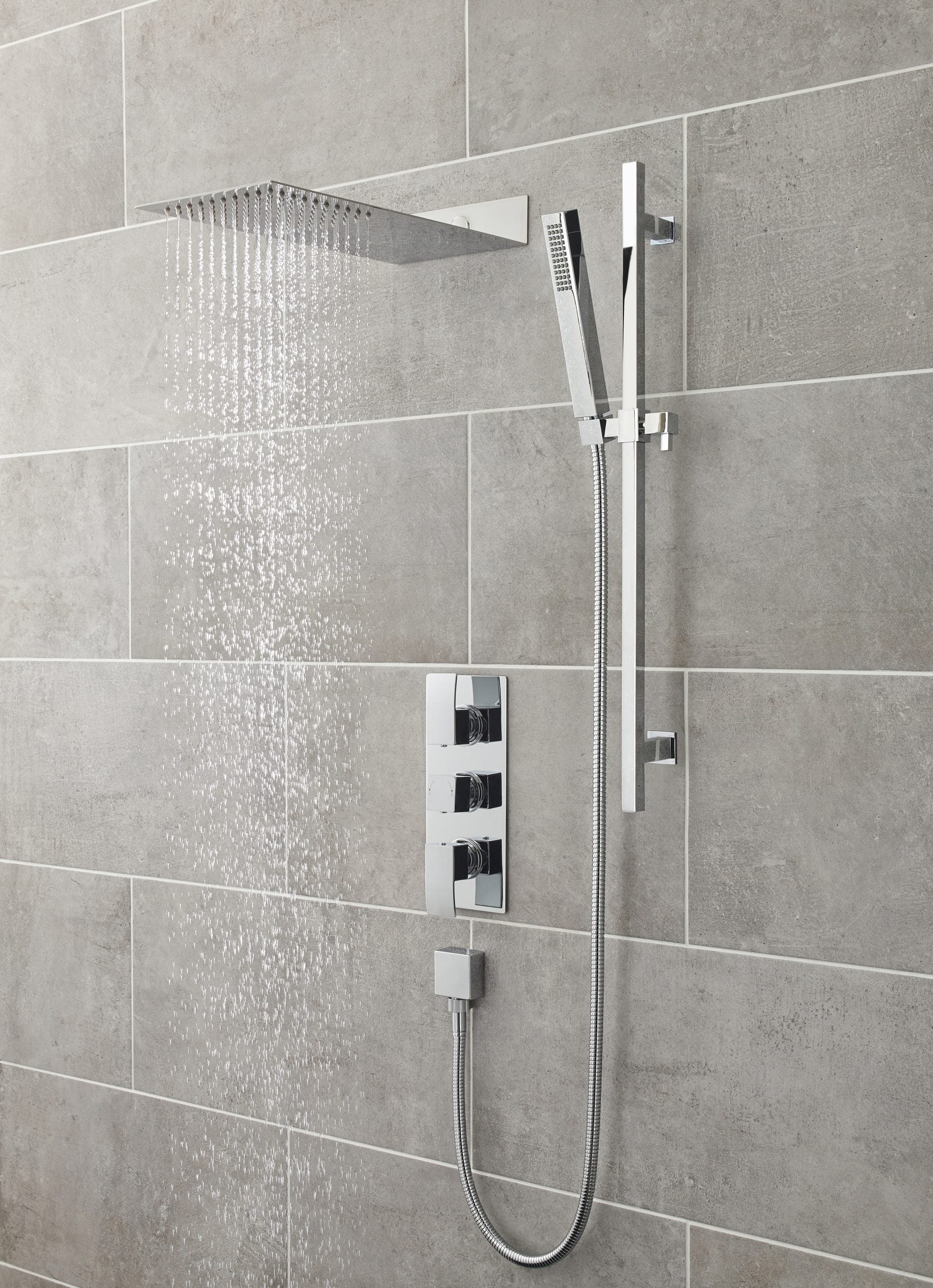 Modern chrome rainfall shower with handheld attachment in a contemporary bathroom, featuring grey tiled walls for a sleek, minimalistic look.