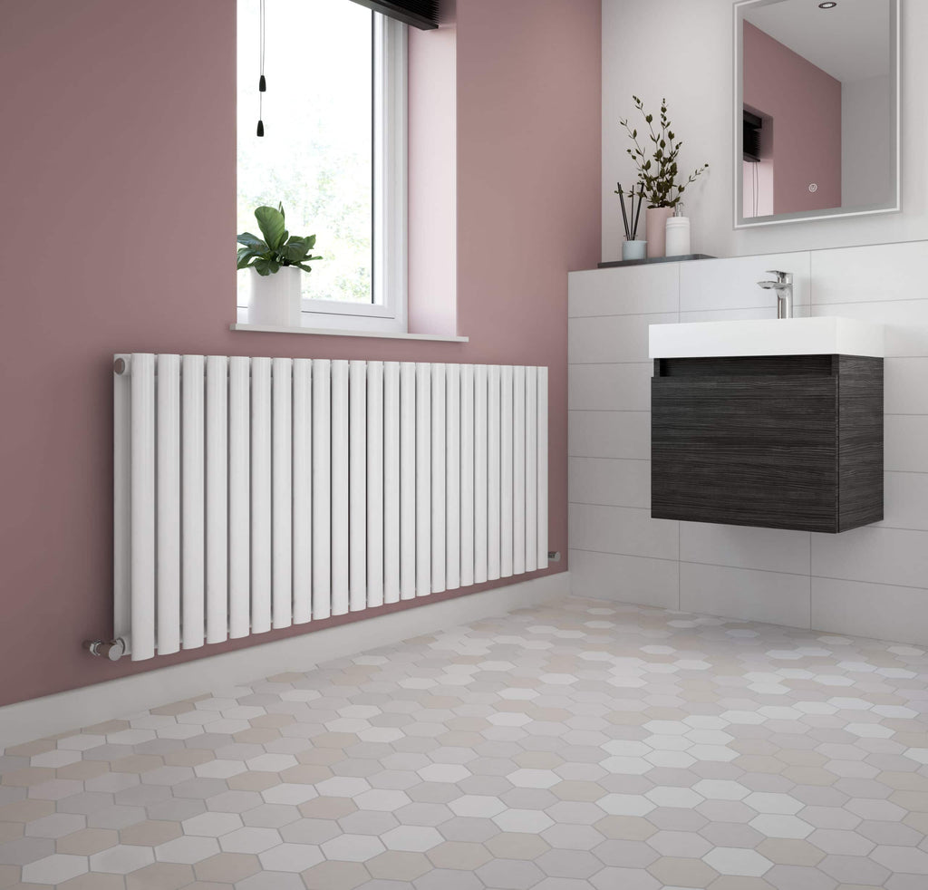 Modern bathroom with white radiator, pink wall, black vanity unit, and small potted plants, showcasing stylish bathroom accessories and contemporary design from Bubly Bathrooms.