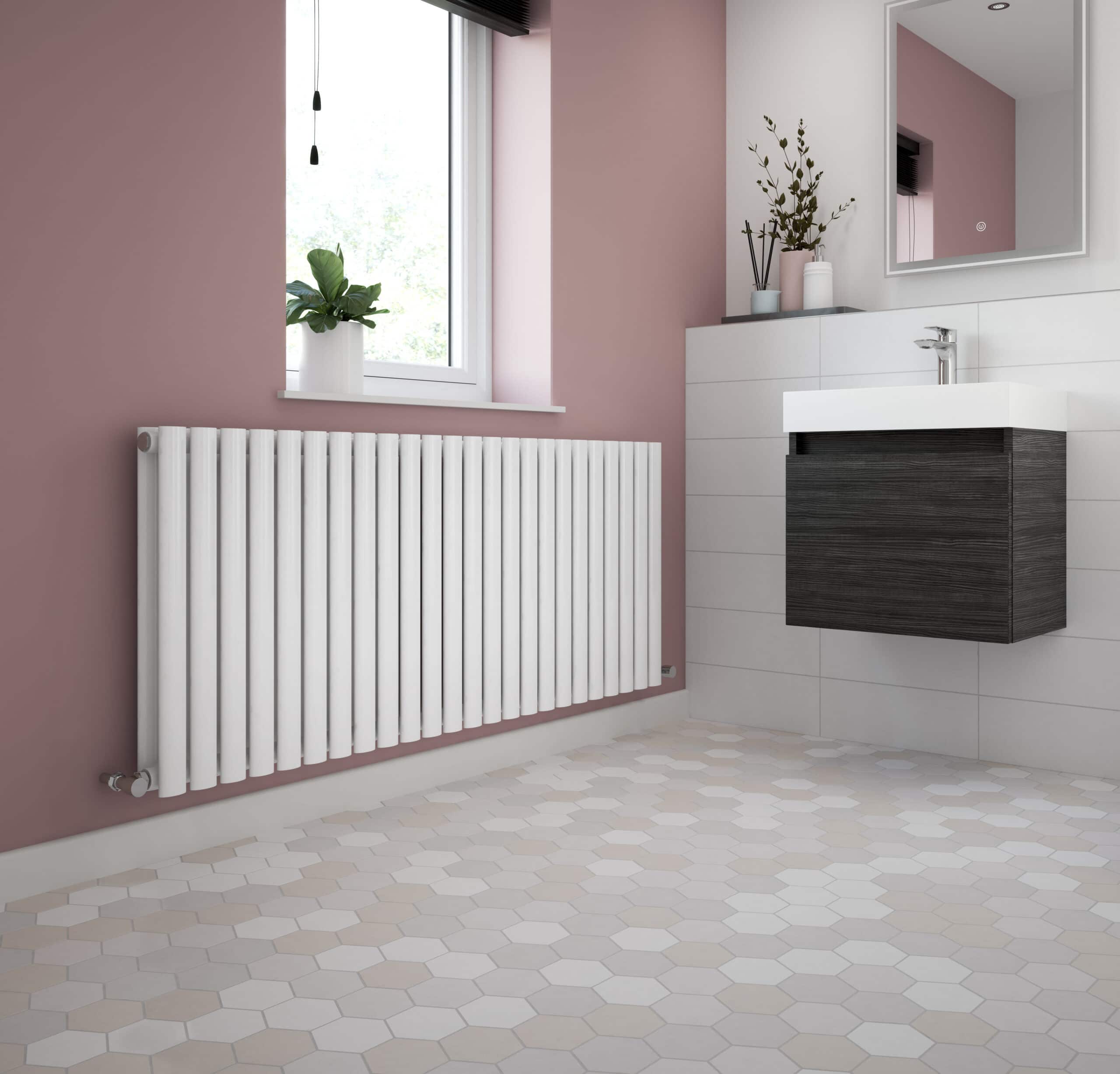 Modern bathroom with white radiator, pink wall, black vanity unit, and small potted plants, showcasing stylish bathroom accessories and contemporary design from Bubly Bathrooms.