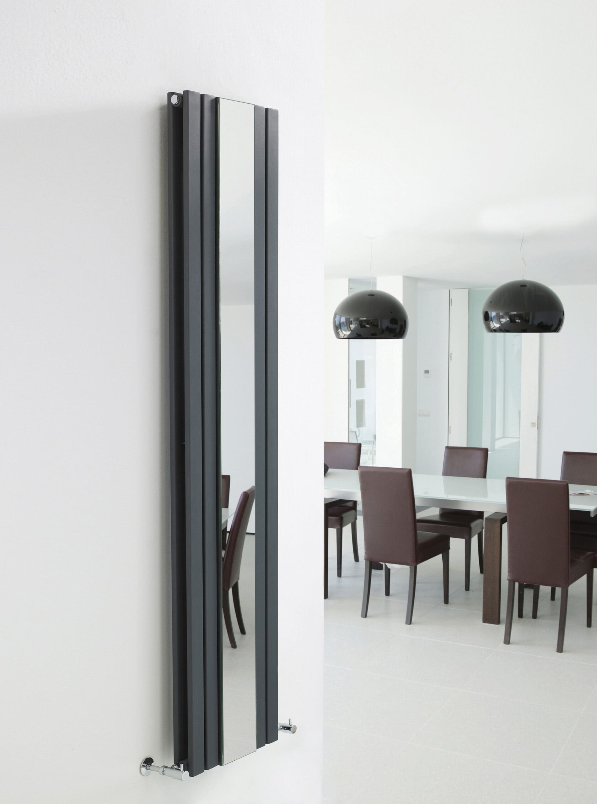 Sleek black vertical radiator in modern bathroom or kitchen, stylish heating solution with minimalist design.