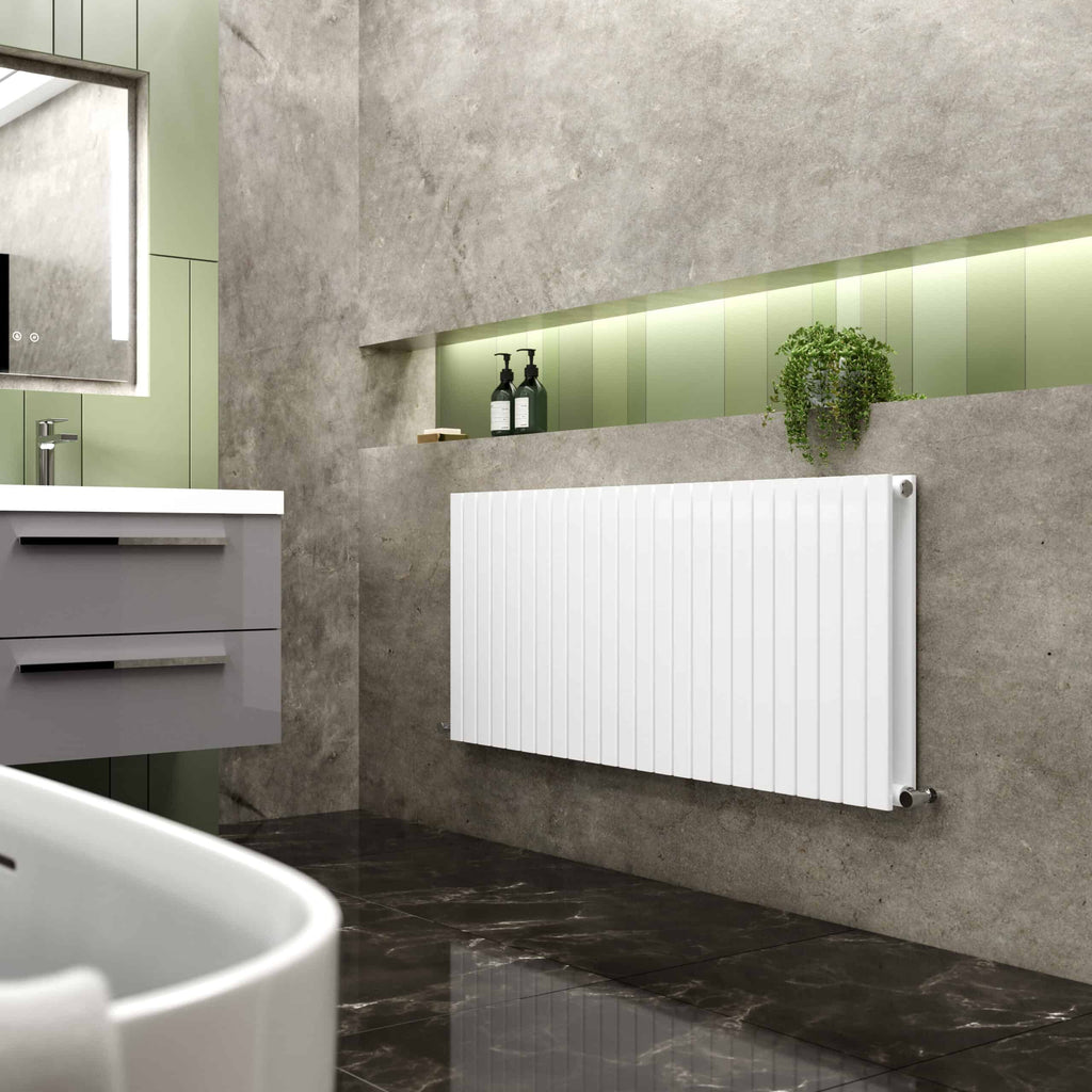 Modern minimalist bathroom featuring a sleek white radiator, grey concrete walls, and green accents, showcasing premium bathroom heating solutions and contemporary design.