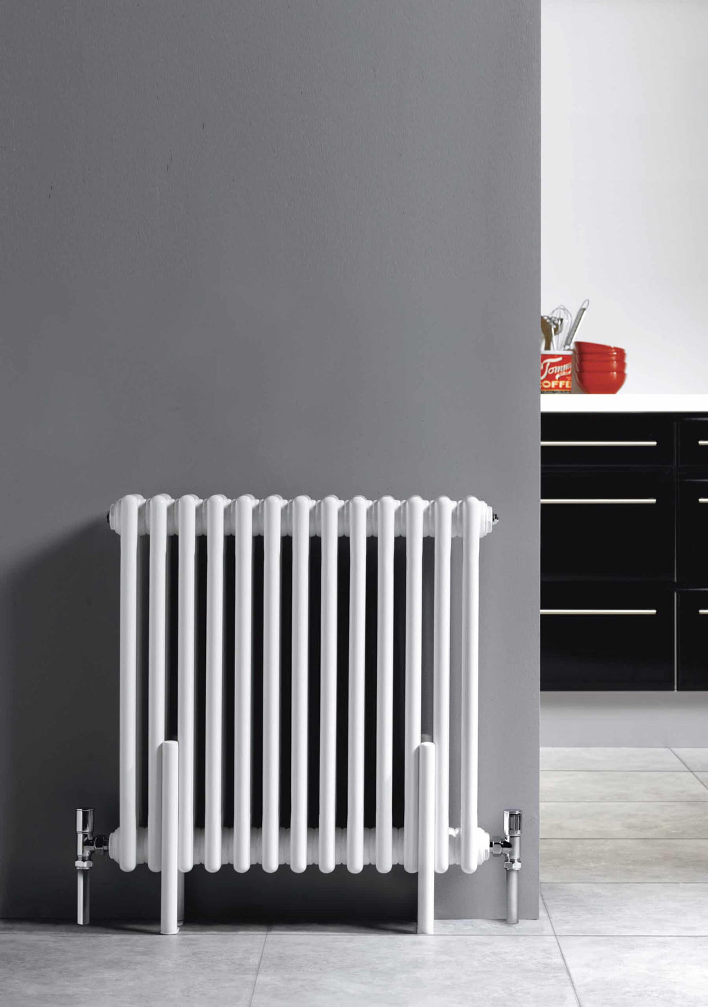 Radiator in modern bathroom with grey wall and black cabinetry, ideal for contemporary bathroom heating solutions.