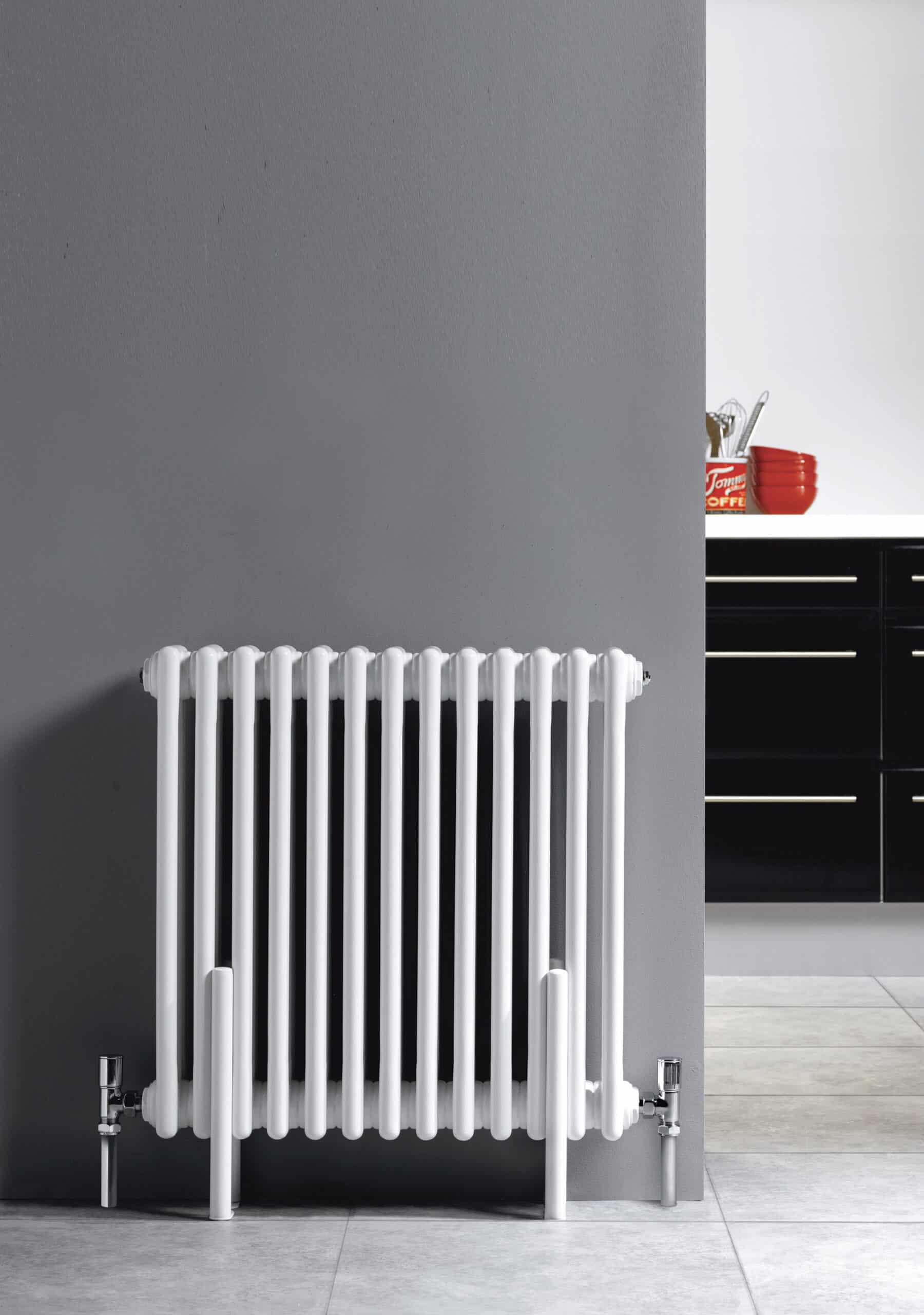 Radiator in modern bathroom with grey wall and black cabinetry, ideal for contemporary bathroom heating solutions.