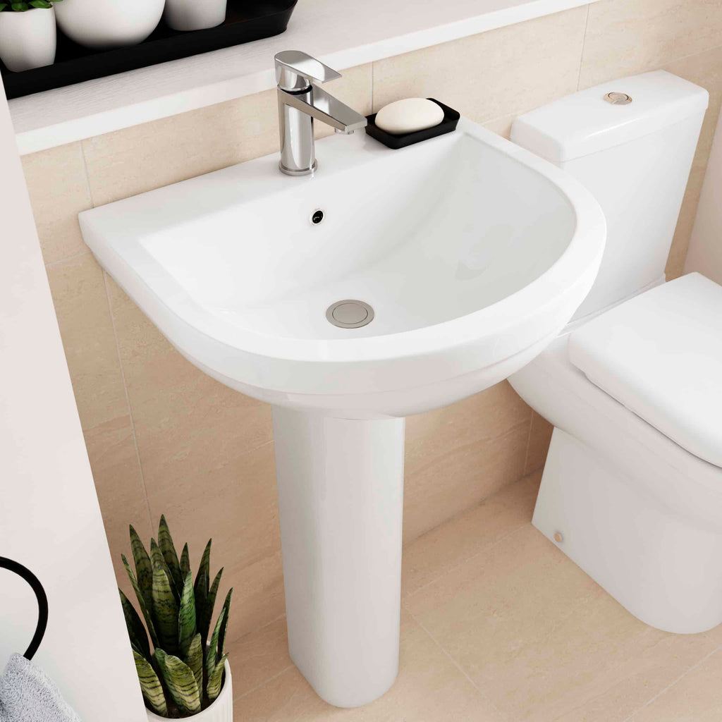 Modern white bathroom sink with sleek chrome faucet and black soap dish, close-up view of Bubly Bathrooms' stylish porcelain pedestal washbasin, perfect for contemporary bathroom designs.
