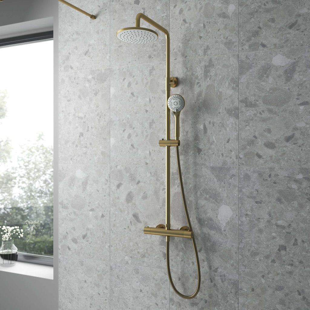 Brass rainfall and handheld shower system in modern bathroom with grey stone tiles, perfect for luxury inspiration and high-end bathroom design.