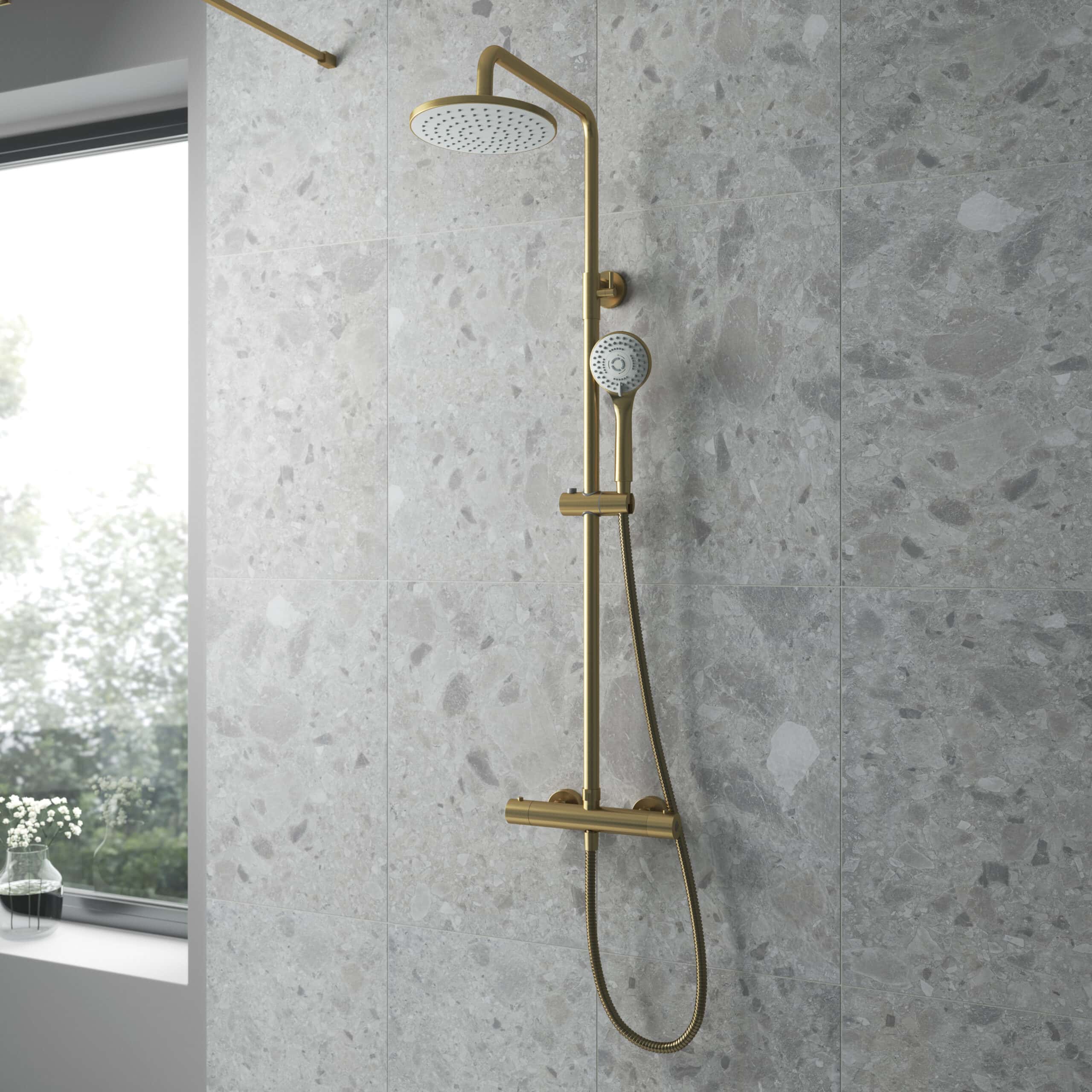 Brass rainfall and handheld shower system in modern bathroom with grey stone tiles, perfect for luxury inspiration and high-end bathroom design.