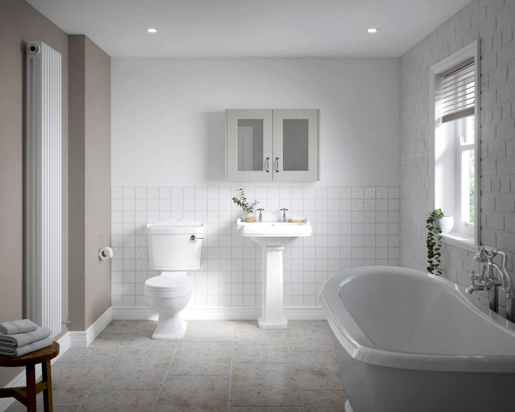 Modern white bathroom with bathtub, toilet, pedestal sink, cabinet, and natural light, perfect for luxury bathroom design and renovation.