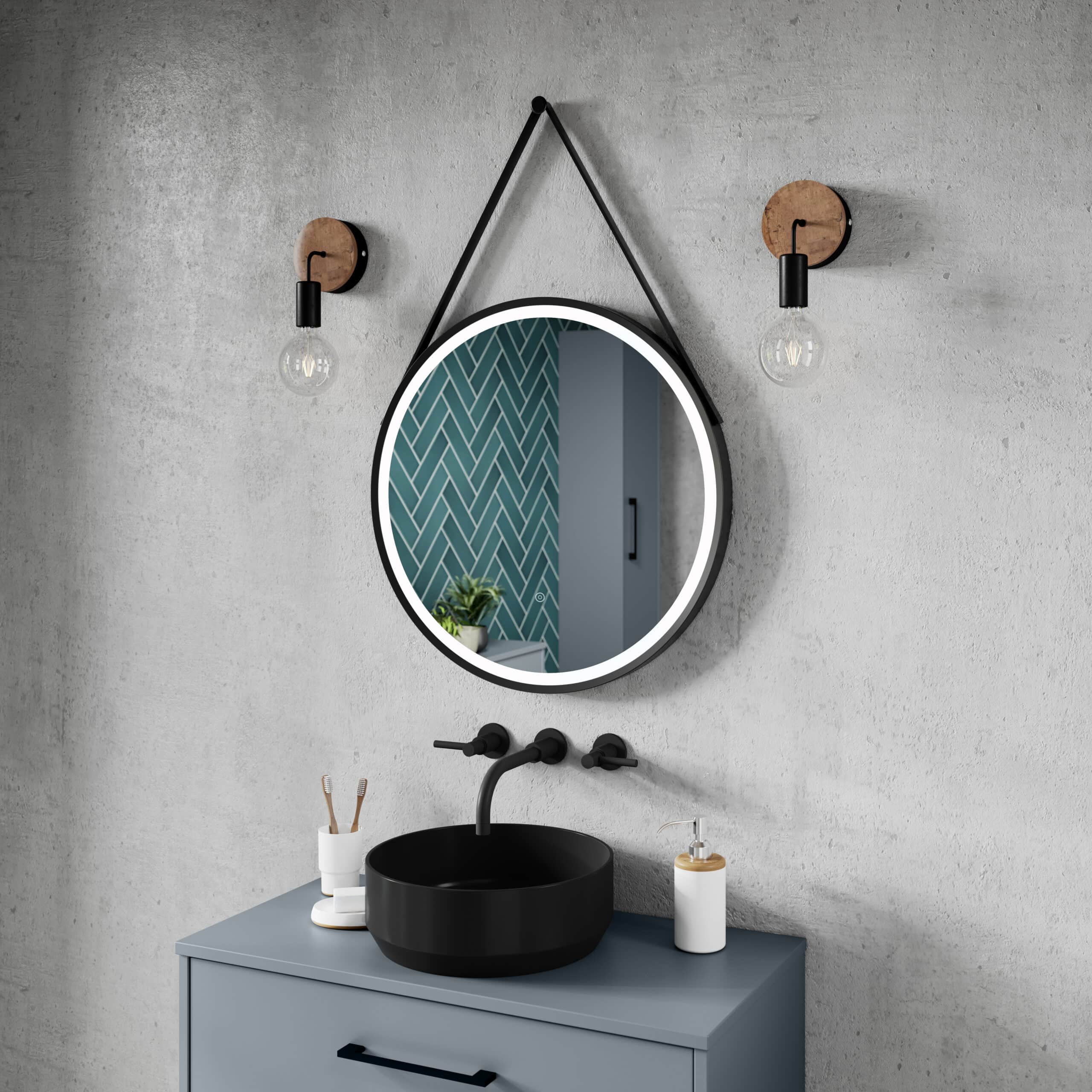 Round illuminated bathroom mirror with black bathroom sink and modern fixtures on grey wall, with stylish lighting and decor, perfect for contemporary bathroom design.
