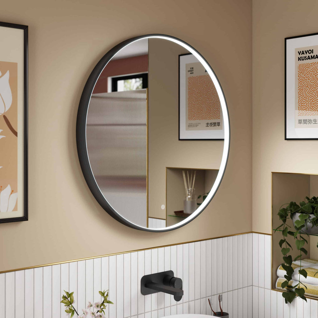 Stylish modern bathroom with illuminated round mirror, beige walls, black fixtures, framed art, and decorative plants, showcasing contemporary Bubly bathroom design and decor.