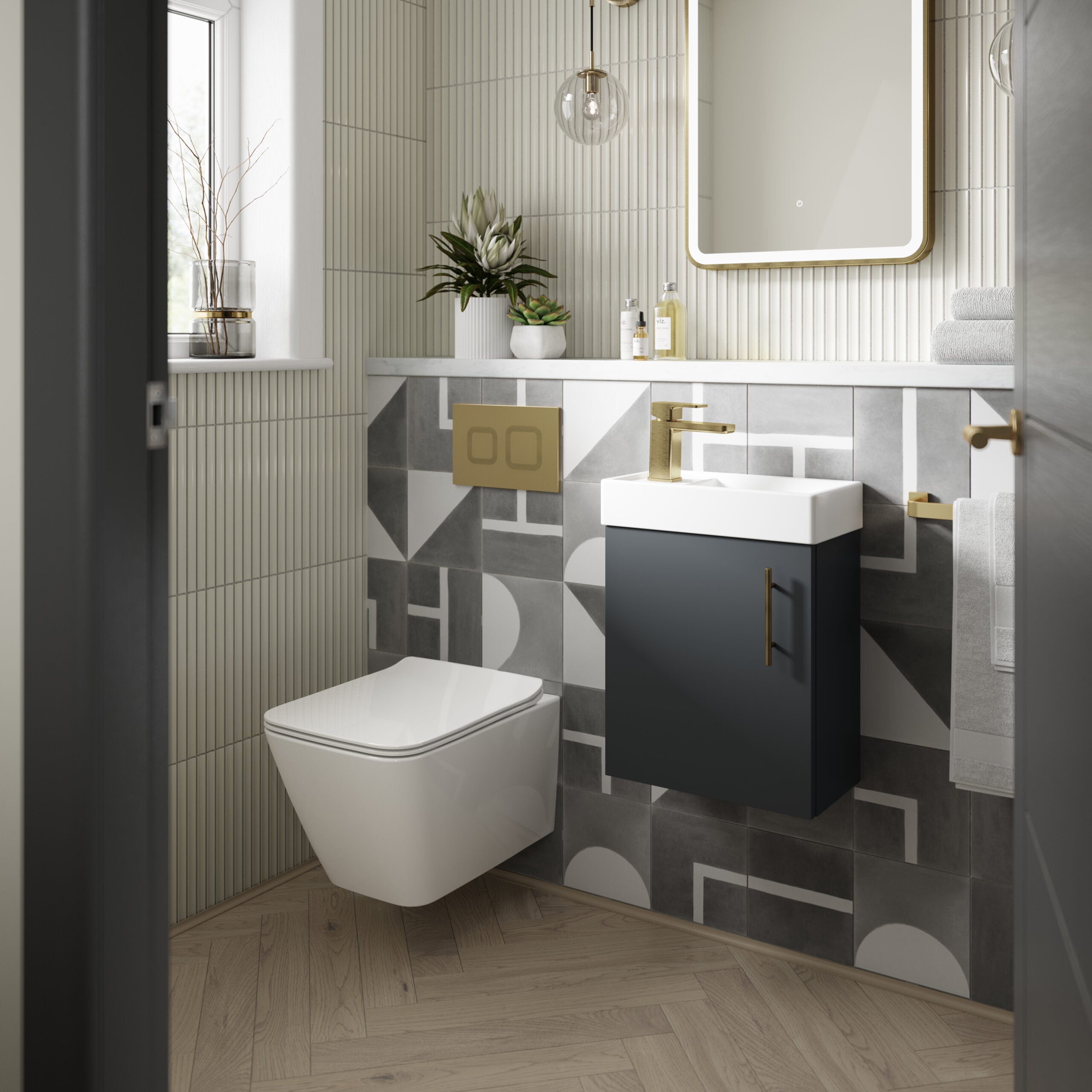 Sleek modern bathroom design featuring a wall-hung toilet, stylish grey geometric tiles, and a contemporary navy vanity with gold fixtures for a luxurious bathroom look.