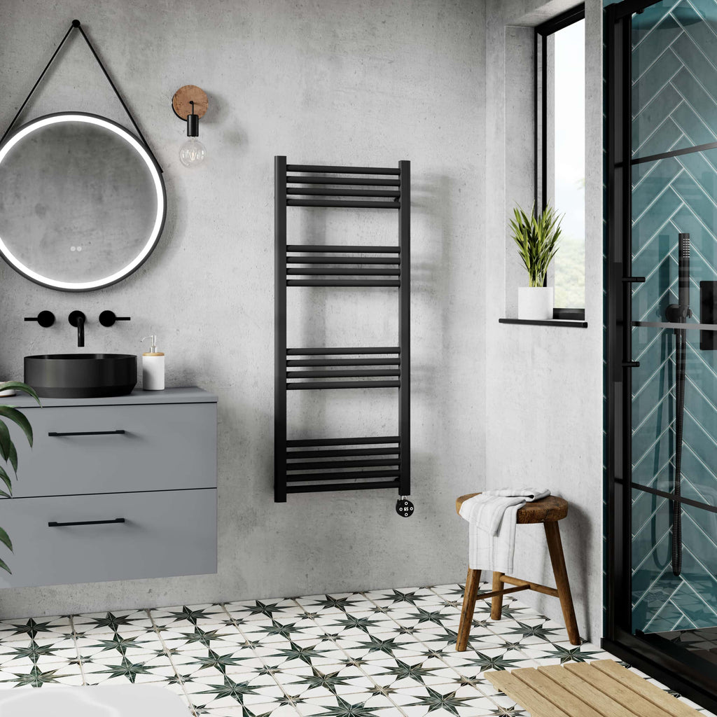 Modern black radiator towel rail in contemporary bathroom featuring a sleek vanity unit, stylish mirror with LED lighting, and a walk-in shower with blue tile accents, creating a luxurious space.