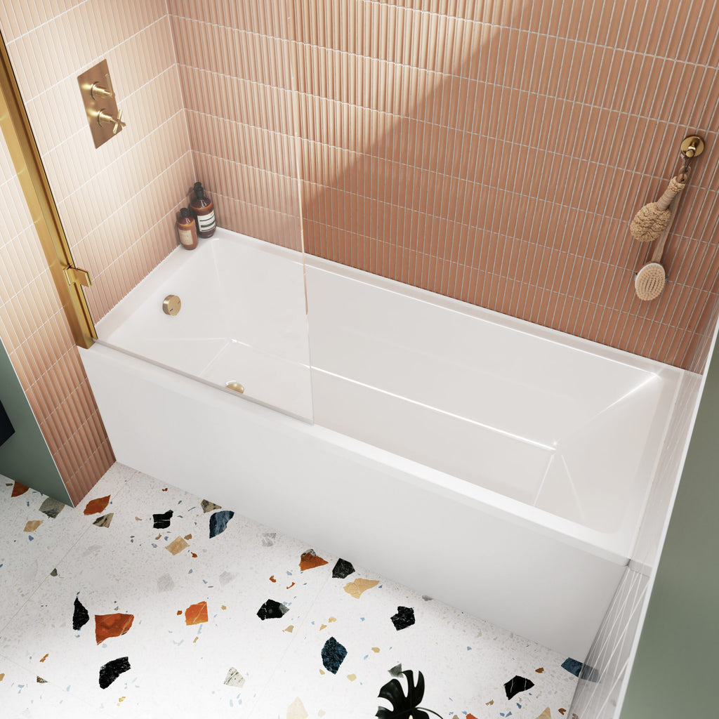 Sleek white bathtub with glass screen and rose gold fixtures in modern bathroom with textured pink tile wall and terrazzo flooring.
