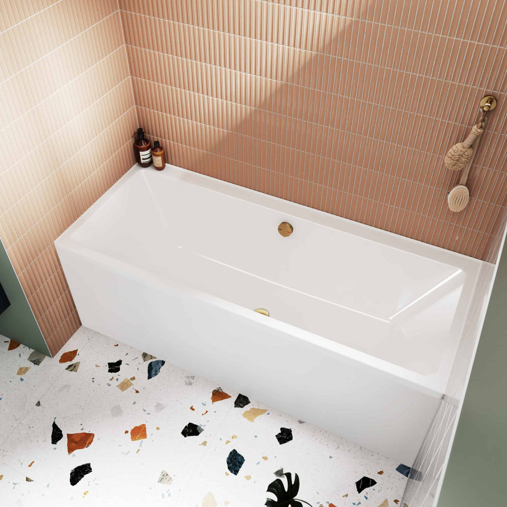 Sleek white bathtub with modern gold fixtures in a contemporary bathroom, featuring pink tiled wall and colourful terrazzo floor, ideal for stylish bathroom renovation and bathing comfort.