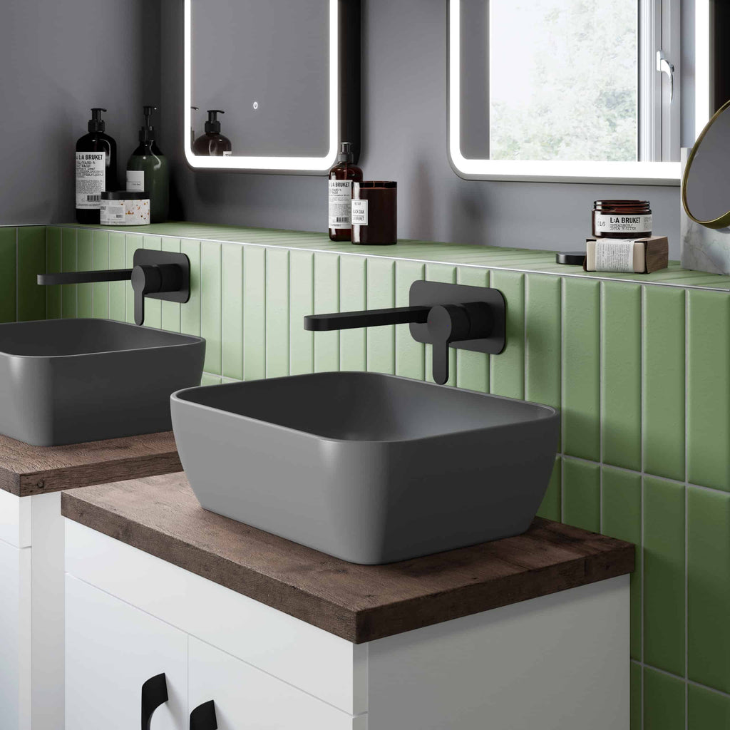 Sleek modern bathroom with grey rectangular sinks, black matte faucets, green tiled wall, and stylish accessories, showcasing contemporary bubly bathroom design with functional aesthetics.