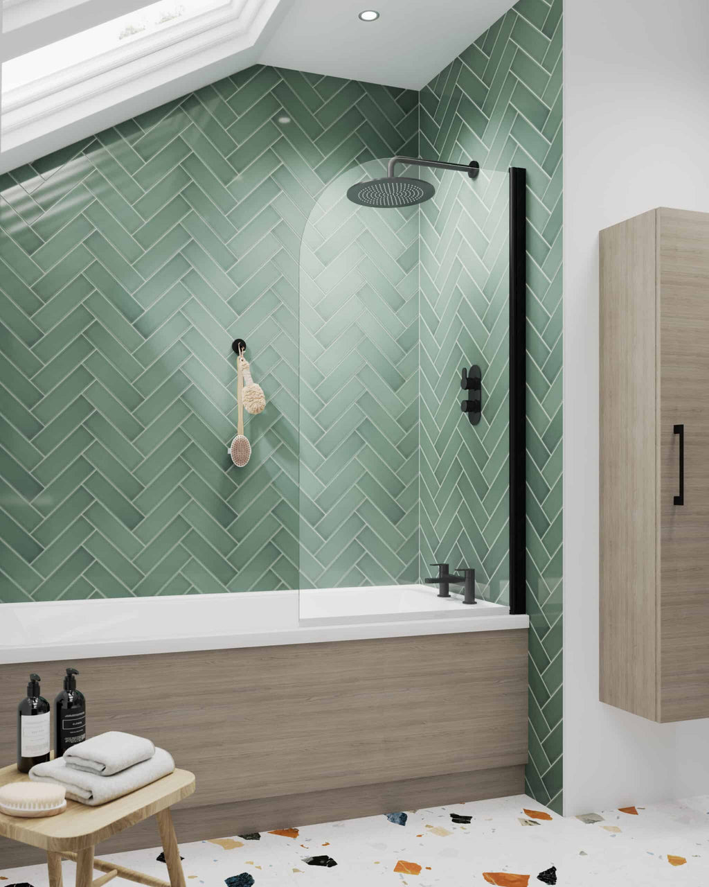 Modern green herringbone tiled shower area with black fixtures and a glass shower screen, detailed with bath products and towels, highlighting stylish bathroom design.