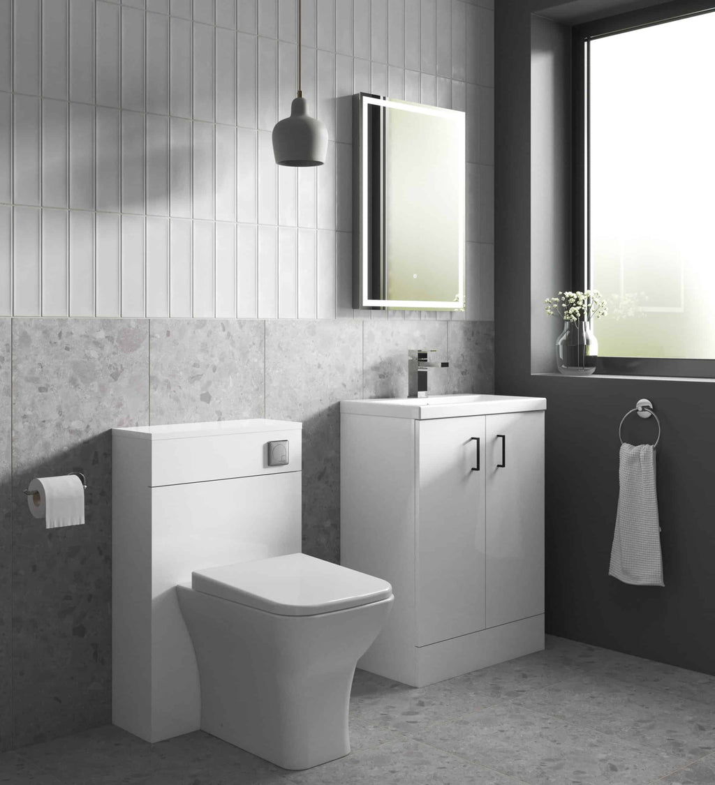 Contemporary bathroom with white toilet and sleek vanity unit, grey tiled walls, and modern lighting, perfect for luxury bathroom design.
