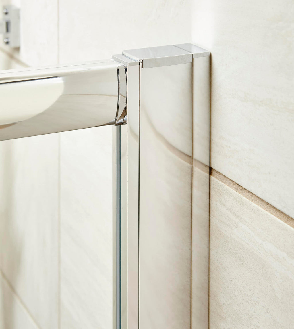 Sleek glass shower enclosure with chrome fittings in a modern bathroom, featuring beige wall tiles, emphasising contemporary design and bathroom renovation details.
