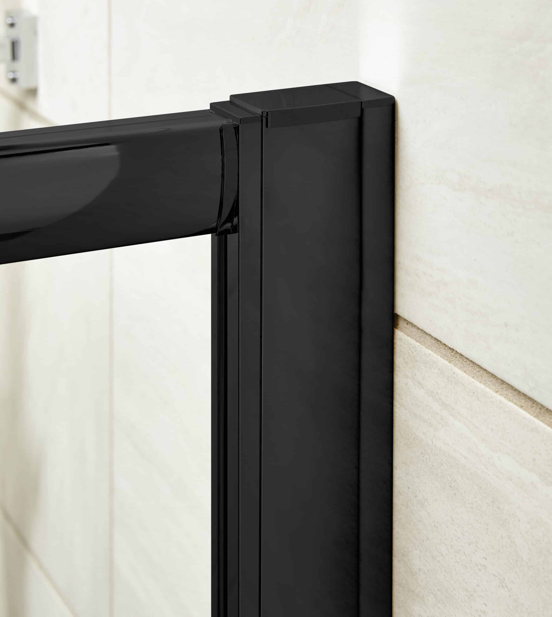 Sleek black bathroom door frame with modern hinges on light beige tiled wall.