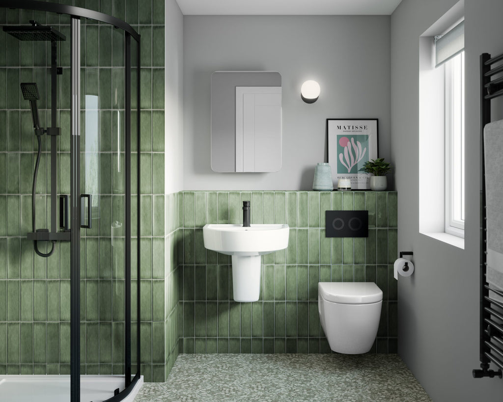 Modern green tiled bathroom with glass shower enclosure, white wall-mounted toilet, stylish sink, and decorative accessories for a contemporary bathroom design.