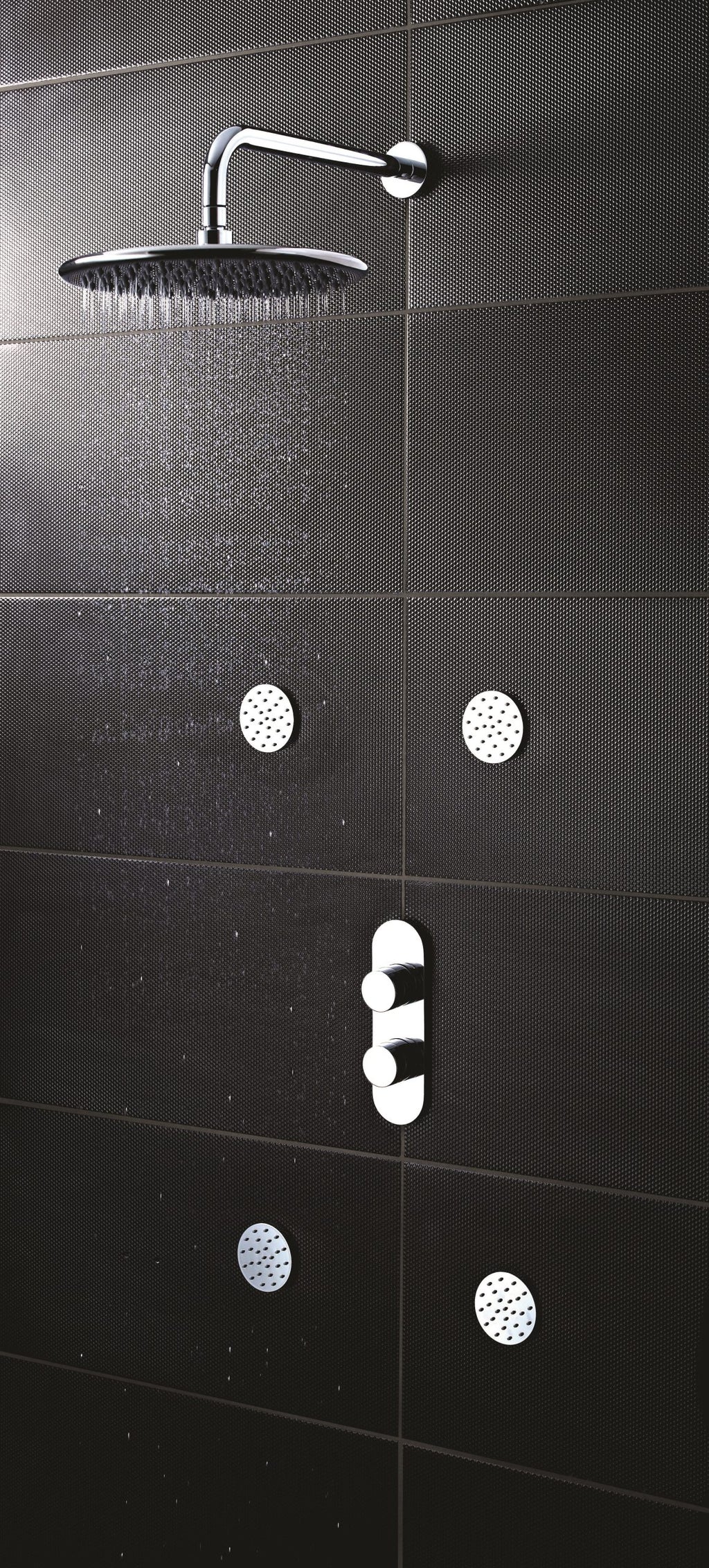Shower head and controls with black textured bathroom tiles, modern shower fixtures.