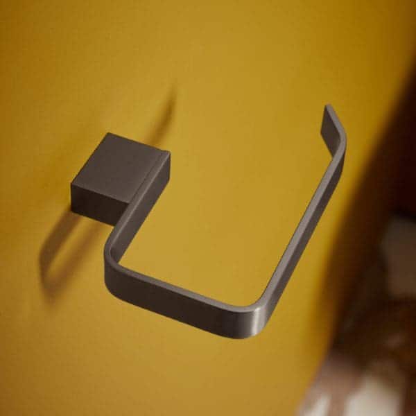 Metal towel ring mounted on a yellow wall, modern bathroom accessory, stylish bathroom towel holder, Bubly Bathrooms product focus, contemporary bathroom design accessory.