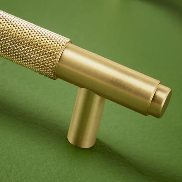 Cricket bat handle with gold finish on a green background, highlighting high-quality bathroom hardware design.