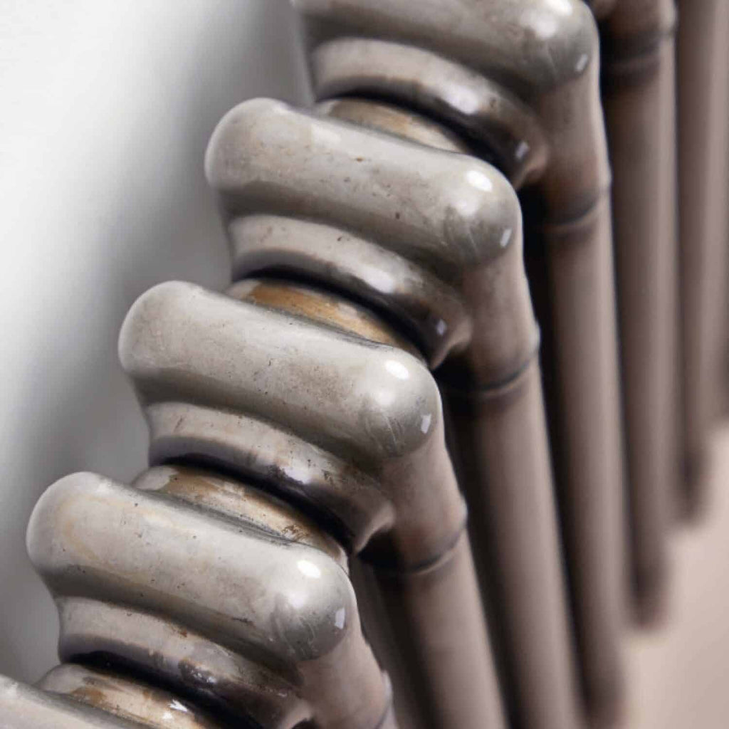 Shower radiator with vintage style, close-up of metallic fins, grey colour, bathroom heating element, modern bathroom decor, Bubly Bathrooms.