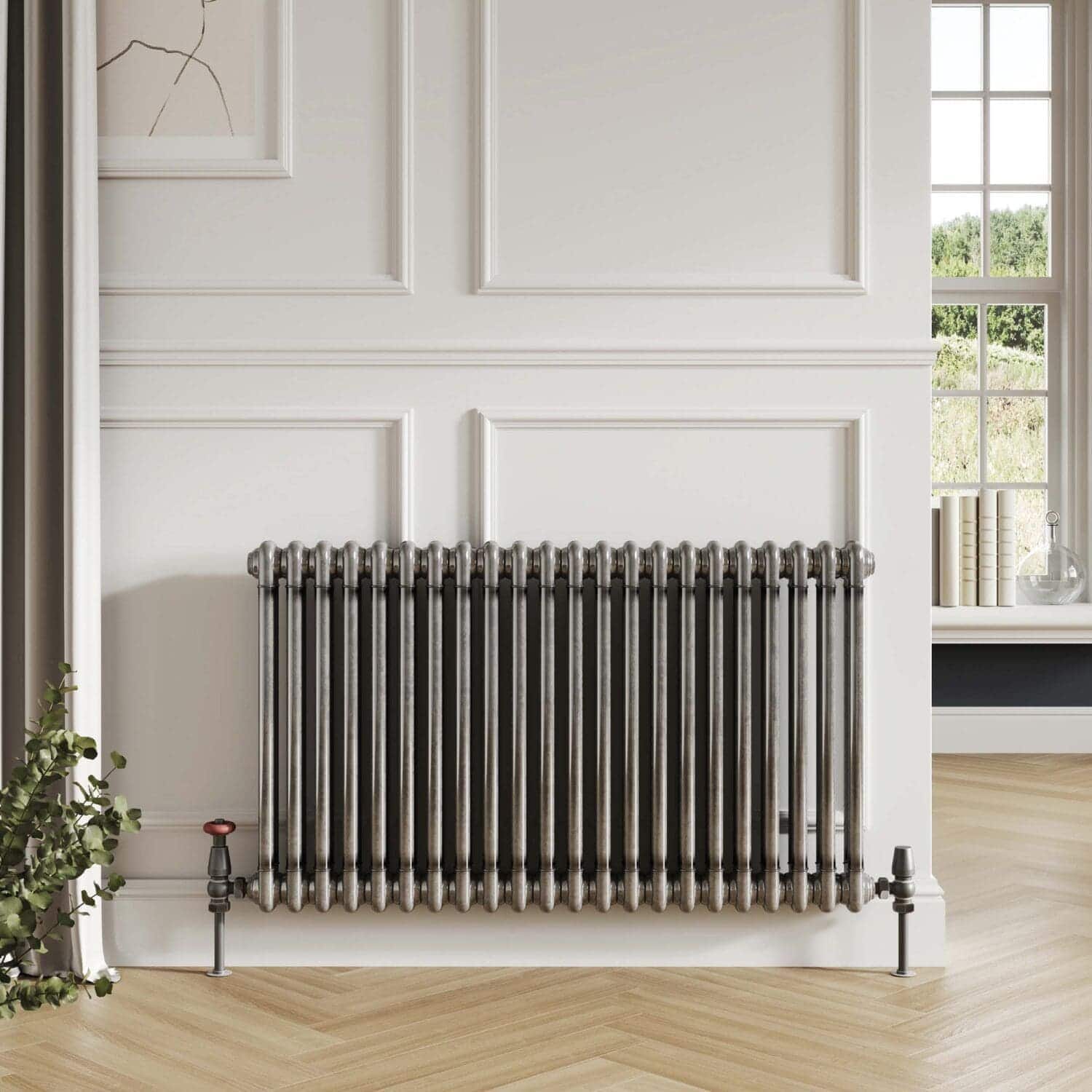 Polished vintage radiator in a modern bathroom setting with white wall paneling and natural light.