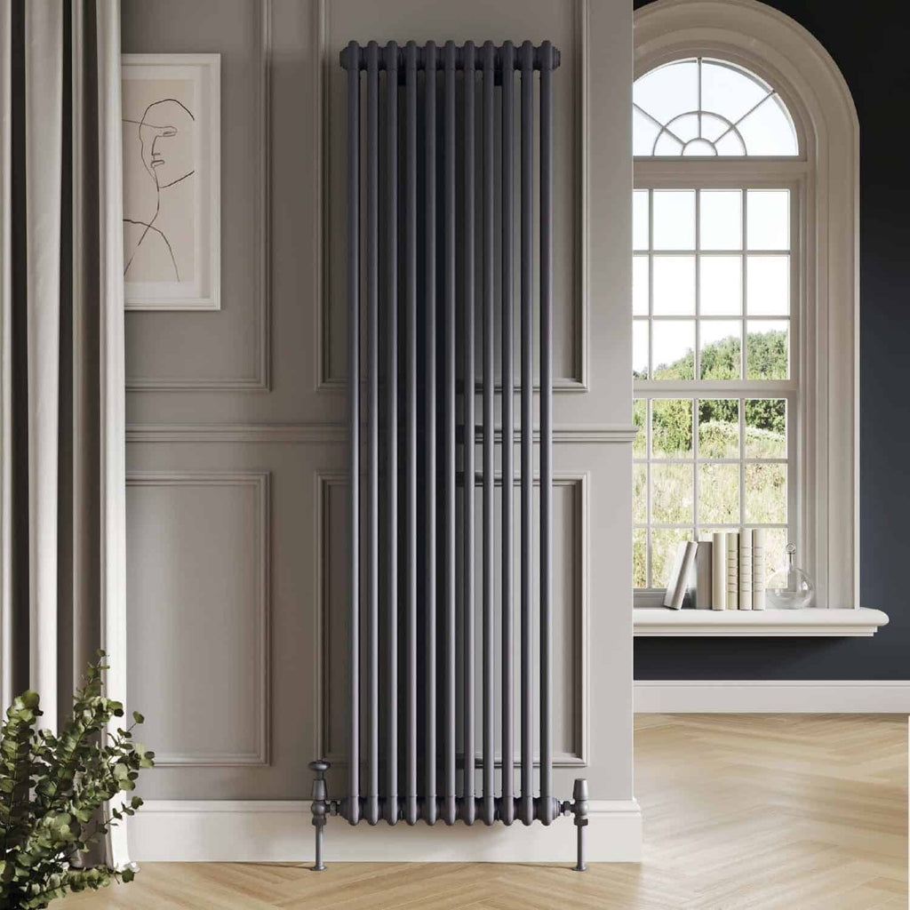 Vertical black cast iron radiator in elegant bathroom with large window and decorative wall paneling, modern central heating radiator design, monochrome interior decor, high-quality home heating solution, Bubly Bathrooms.