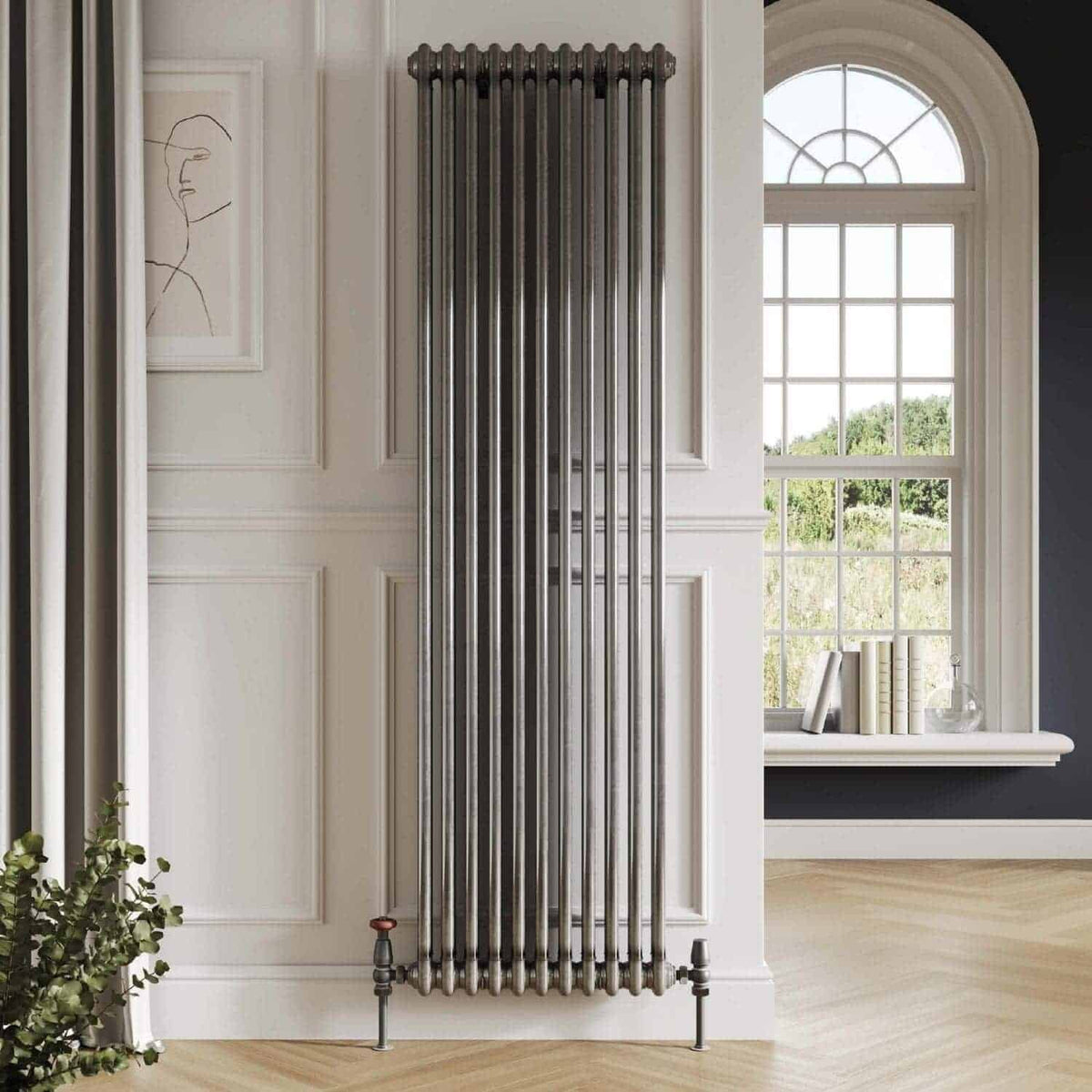 Industrial chrome vertical radiator heating towel rail in a modern bathroom with large window and elegant decor.