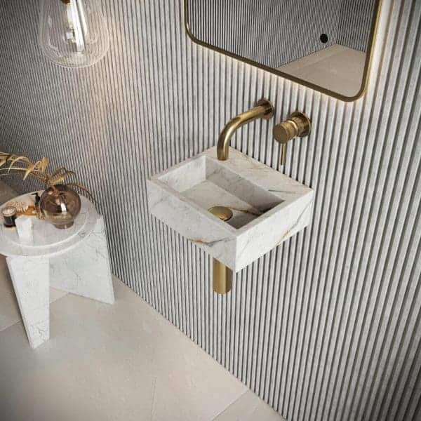 Sleek white marble wall-mounted bathroom sink with gold fixtures and contemporary design, ideal for modern bathroom renovation and luxury interior decor.