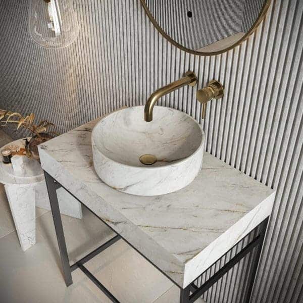 Marble bathroom vanity with gold faucet and round ceramic sink in contemporary bathroom decor.
