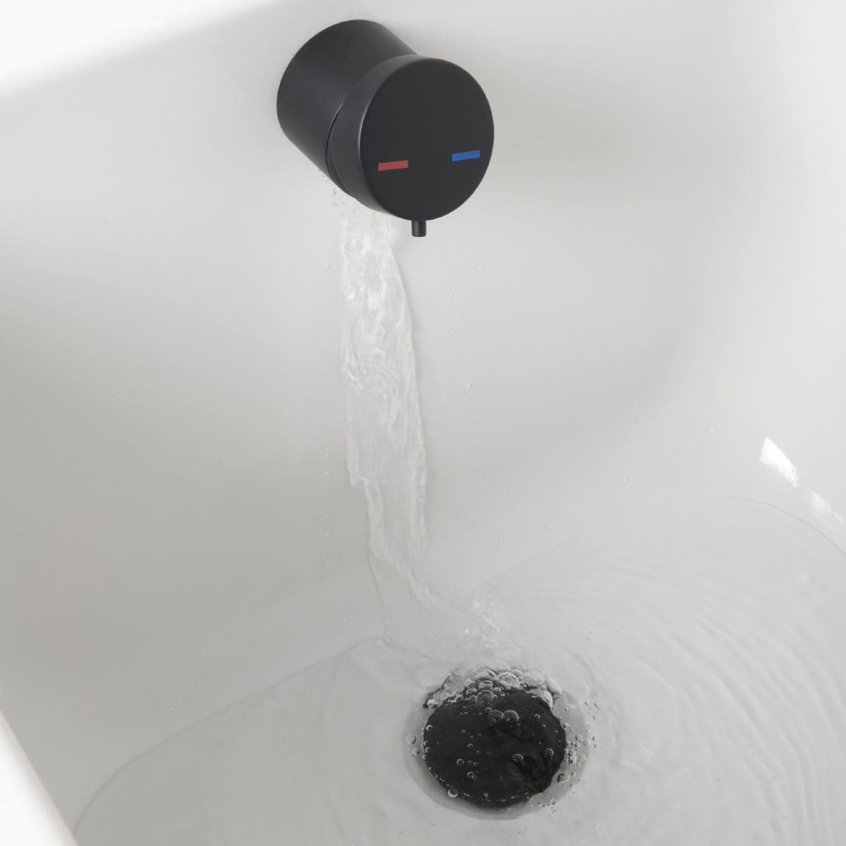 Flowing water from a black and blue thermostatic tap in a modern bathroom.