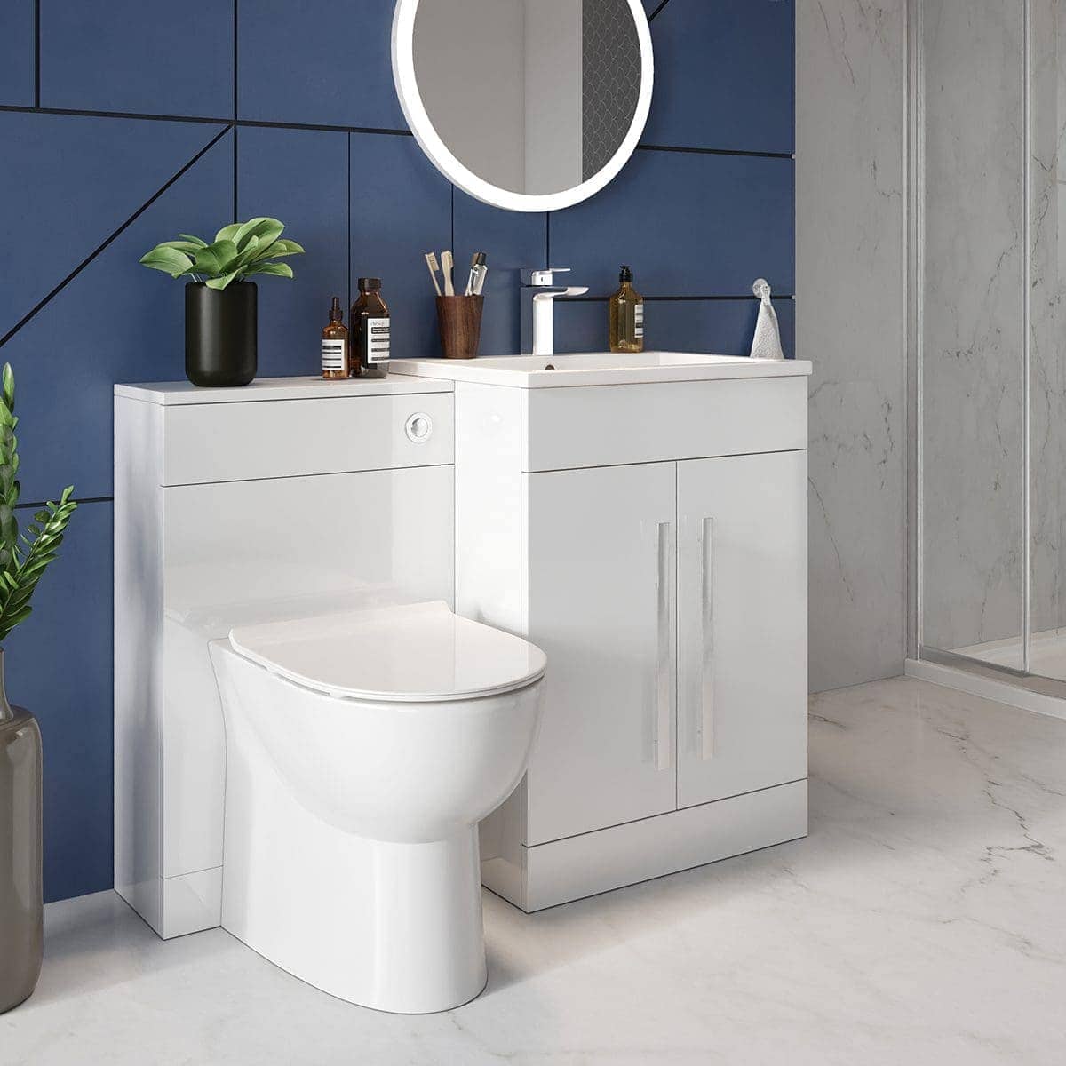 Sleek white bathroom vanity with integrated toilet and modern black accessories, set against bold blue and grey tiled walls, creating a contemporary and stylish bathroom design.