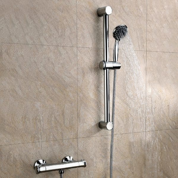 Shower rail with handheld shower head and adjustable sliding bar in a modern bathroom with beige tiled wall.
