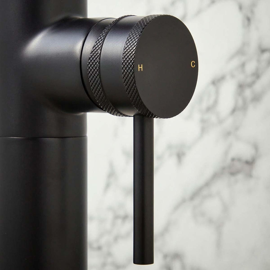 Black thermostatic shower control knob with H & C markings for hot and cold water adjustment, modern bathroom fixture.