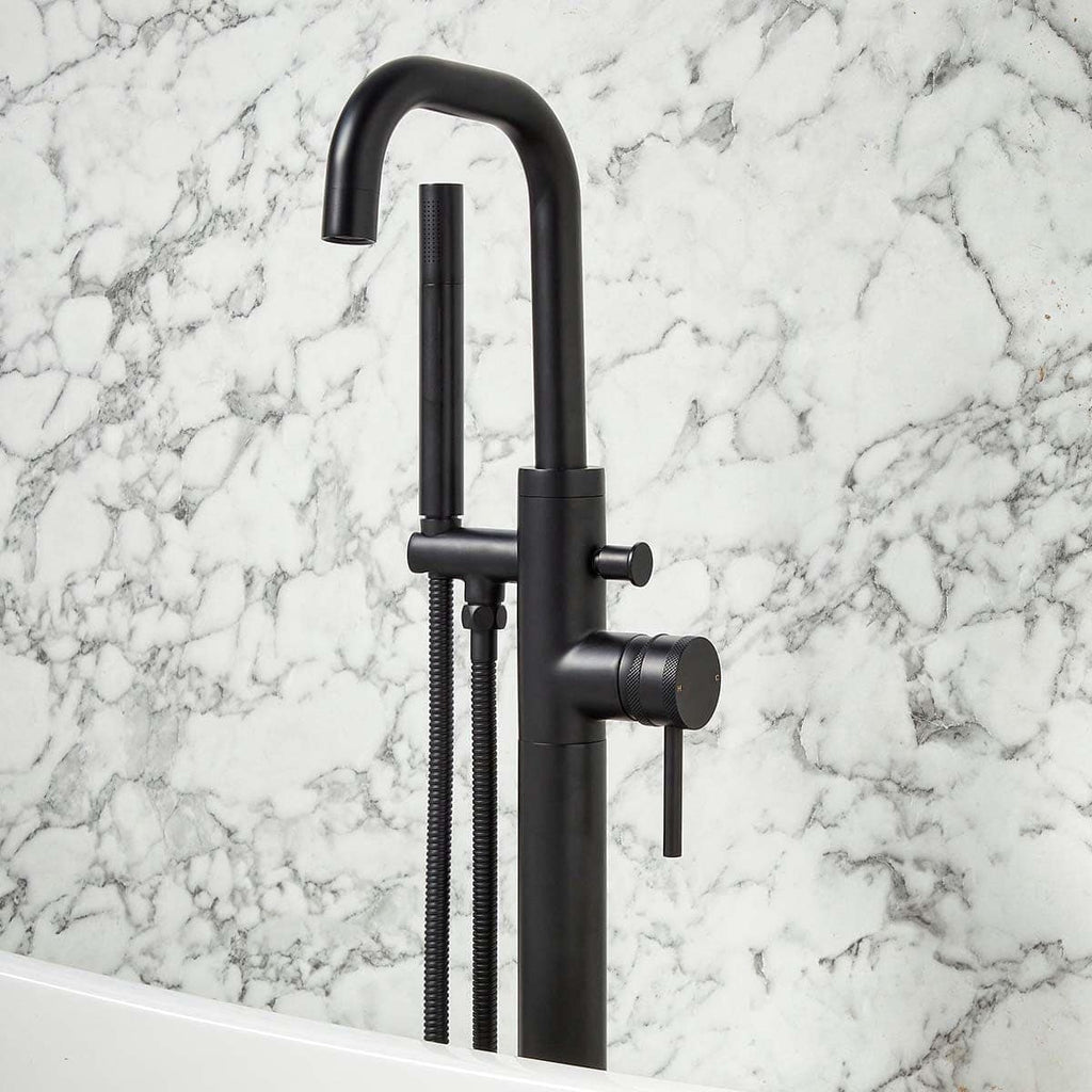 Brushed black kitchen sink tap with flexible hose and modern design in front of marble wall, stylish bathroom or kitchen fixture for contemporary homes.