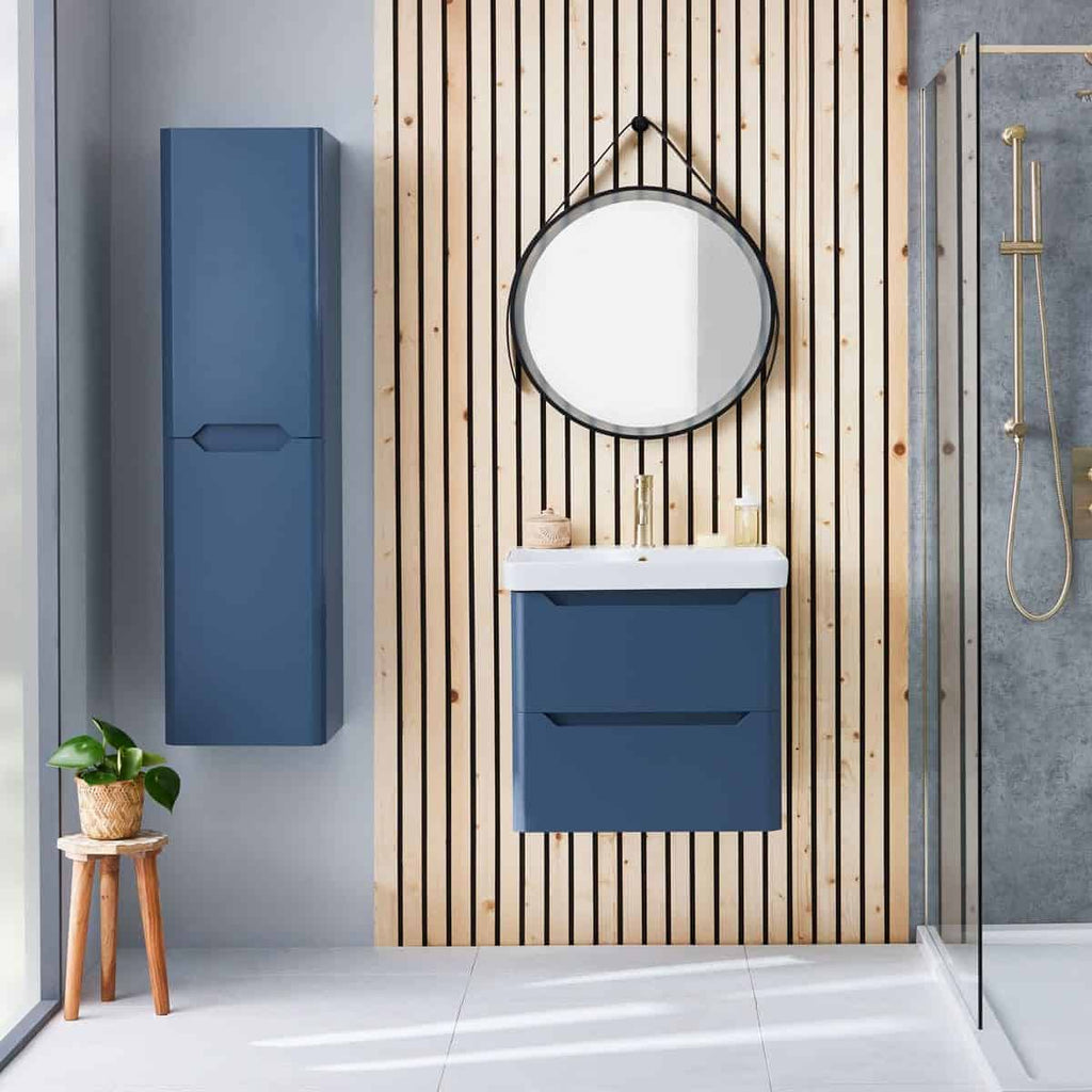Rustic blue bathroom vanity with wall-mounted cabinet, round mirror, and modern shower area, perfect for contemporary bathroom design and storage solutions.