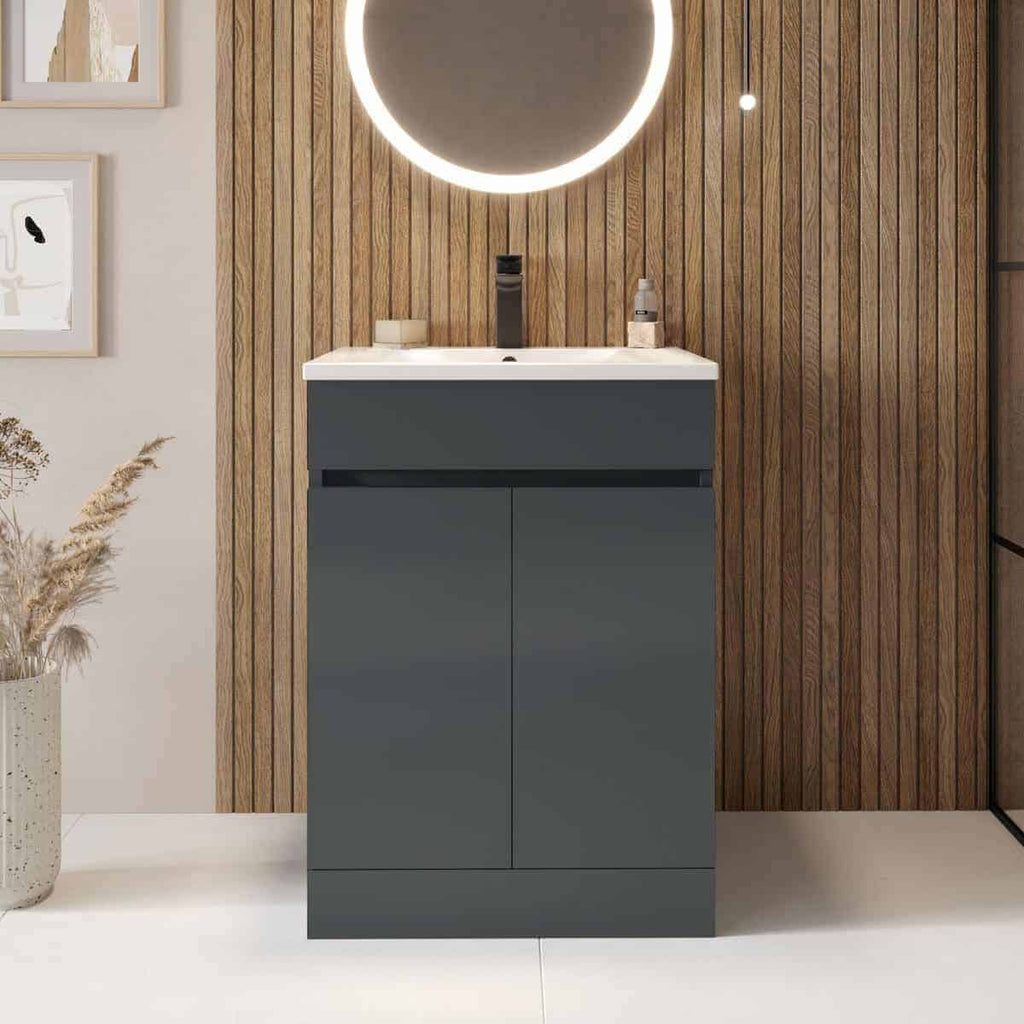 Sleek modern bathroom vanity with integrated sink and matte grey finish, suitable for stylish bathroom design. Features a round backlit mirror and wood paneling for contemporary home bathroom decor.