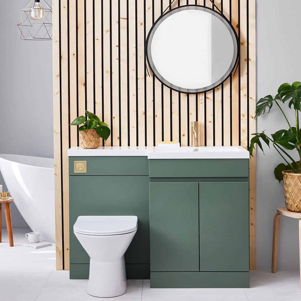 Contemporary bathroom with green vanity unit, round mirror, wooden wall decor, potted plants, and modern fixtures, showcasing stylish bathroom furniture and design ideas from Bubly Bathrooms.