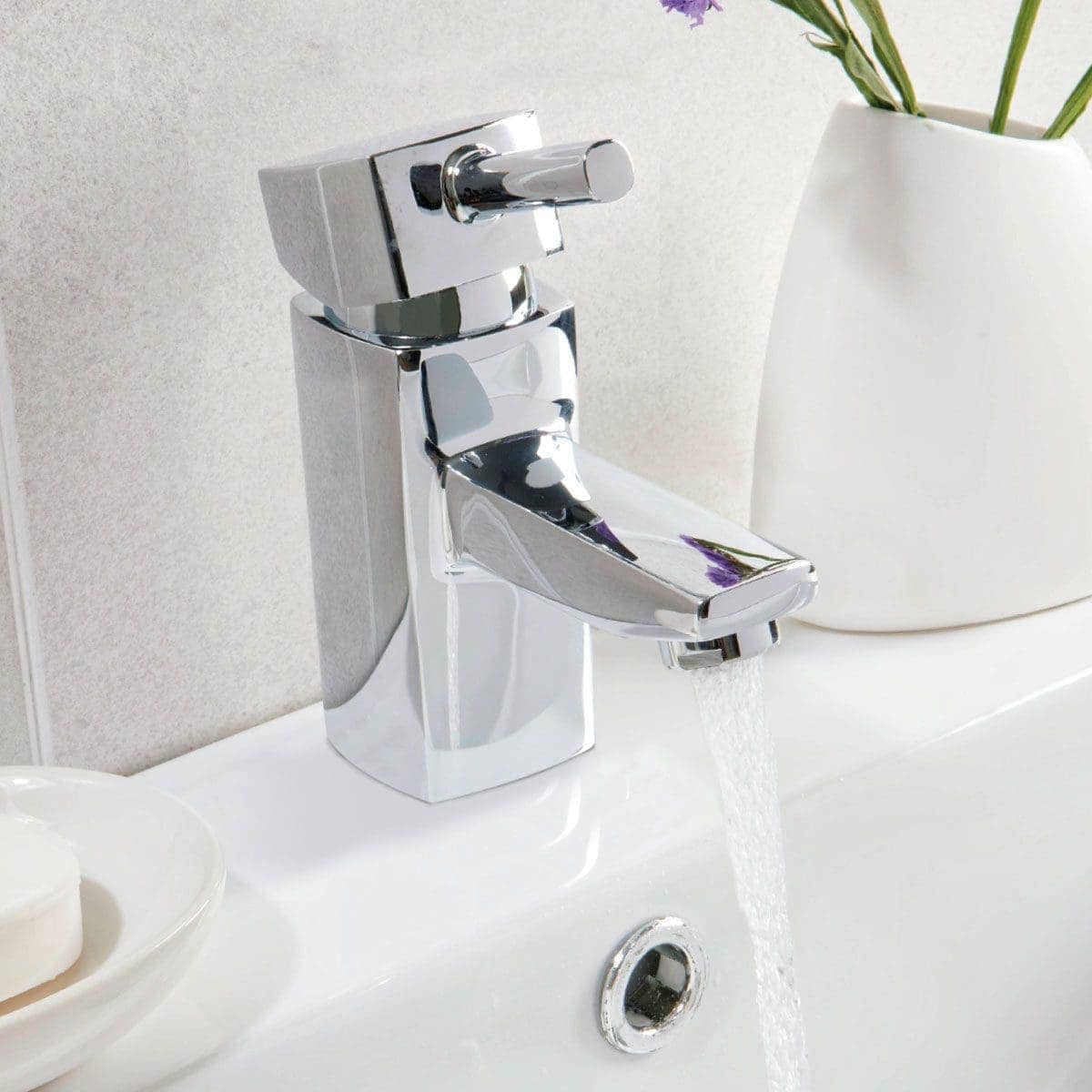 Brushed chrome bathroom tap, modern basin mixer with water flowing, sleek and stylish design, plumbing fixture for contemporary bathrooms, high-quality chrome finish for durability and elegance.