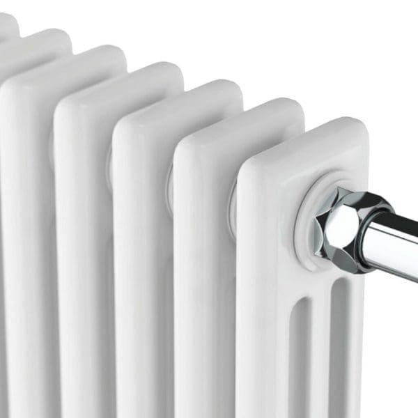 Radiator close-up showing white radiator with chrome pipe fitting in a modern bathroom setting.