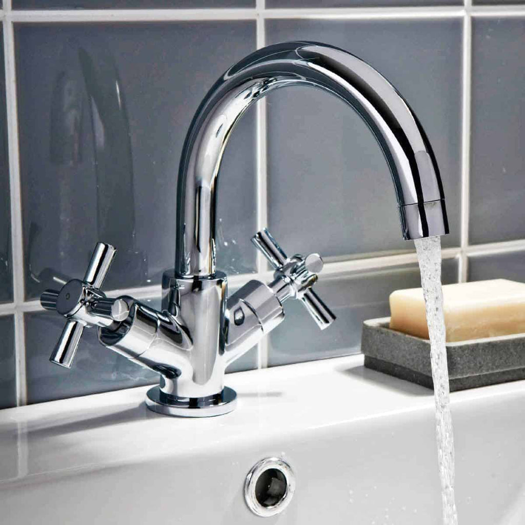 Shiny chrome bathroom mixer tap with running water, modern kitchen or bathroom fixture, close-up view.