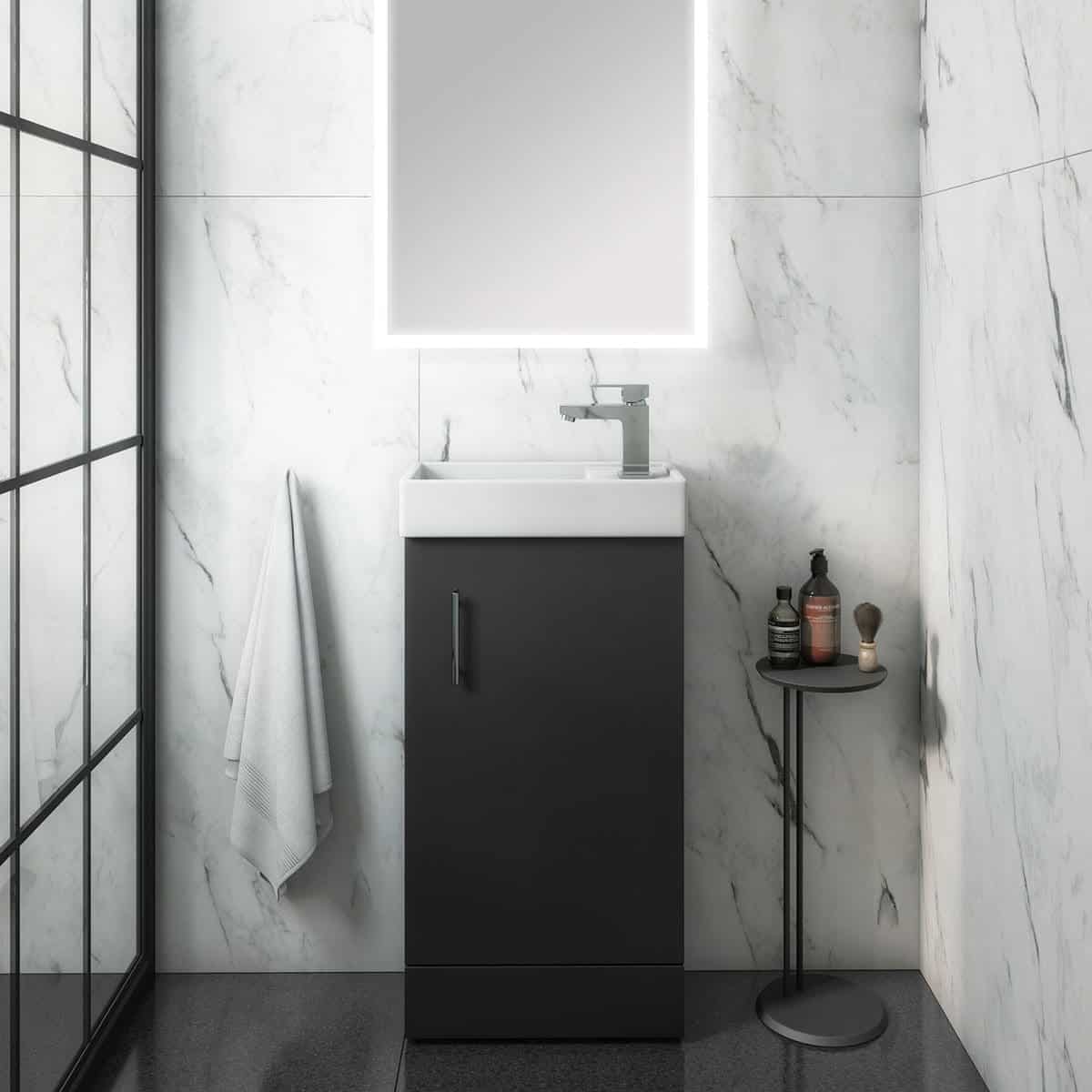 Sleek modern bathroom vanity with a black cabinet, white sink, and minimalist chrome faucet, set against marble-effect walls and minimalist accessories, ideal for contemporary bathroom designs.