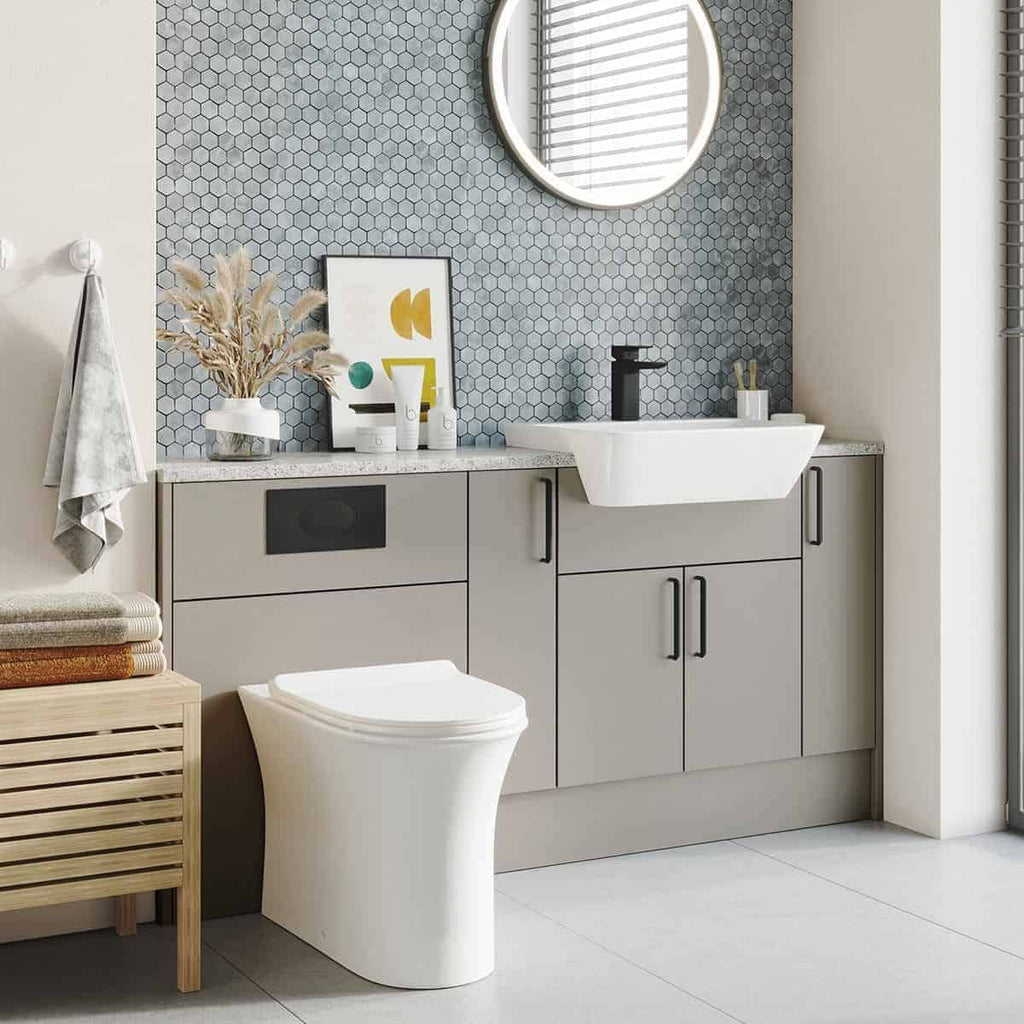 Contemporary grey bathroom vanity with integrated sink, black faucet, hexagonal tile backsplash, and minimalist decor in a modern bathroom setting.
