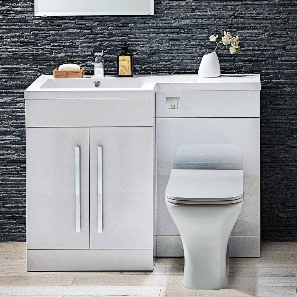 Modern white bathroom vanity with integrated sink and toilet, against a textured black stone wall, showcasing sleek design and contemporary bathroom furniture for optimal space and style.